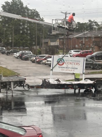 The Community surrounding the Towncrest Center while their street sign is being installed.