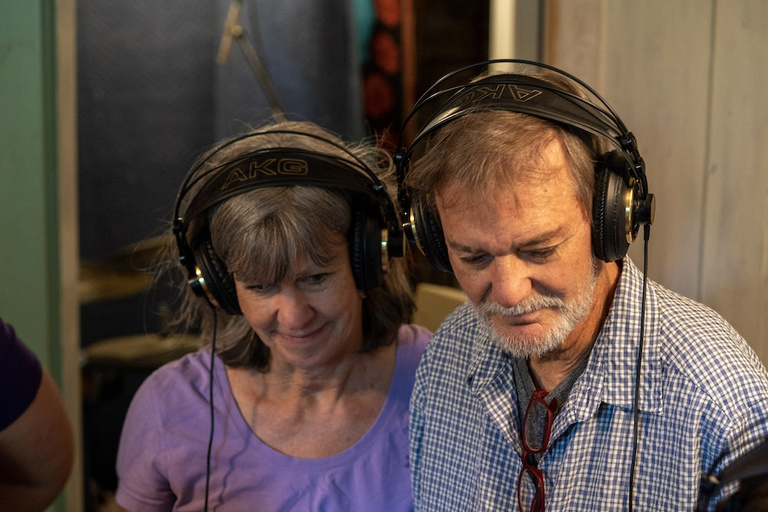 A woman and a man wearing headphones. 