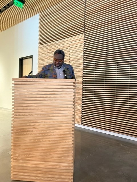 Black man speaking behind a podium