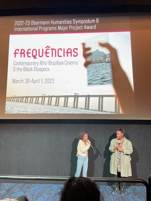 2 black women talking in front of the Frequencias Poster