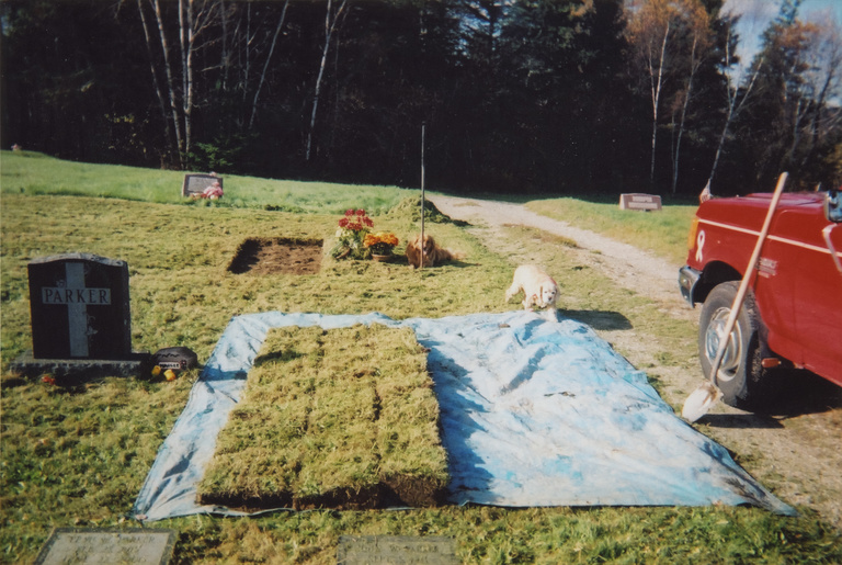sod squares laid out on tarp beside open grave
