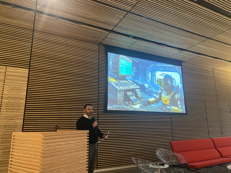 faculty member speaking while showing photos on a screen at art museum