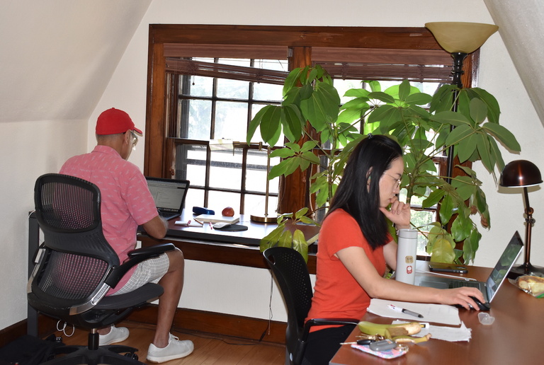 people writing at desks