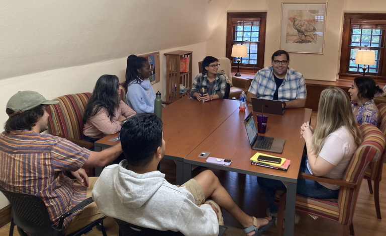 people writing and talking at desks
