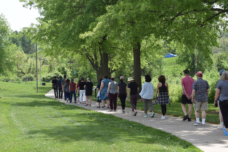 People walking down a sidewalk in a park