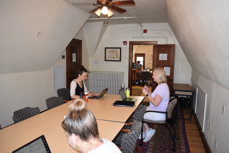 people writing at desks
