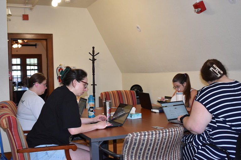 people writing at desks