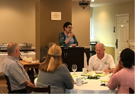 People at awards ceremony; Bern-Klug speaking at lectern