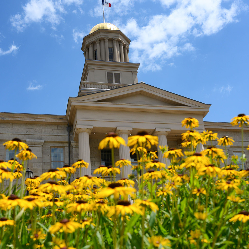 Old Capitol Museum facade in summer, with flowers