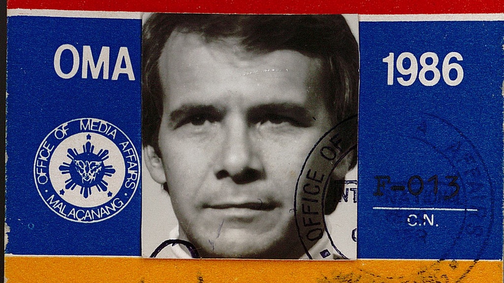 A press pass with a man's face, dated 1986.