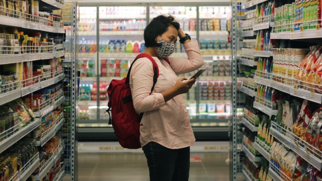 Woman grocery shopping, scratching her head