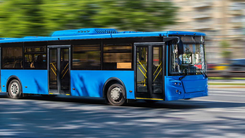 city bus driving along street
